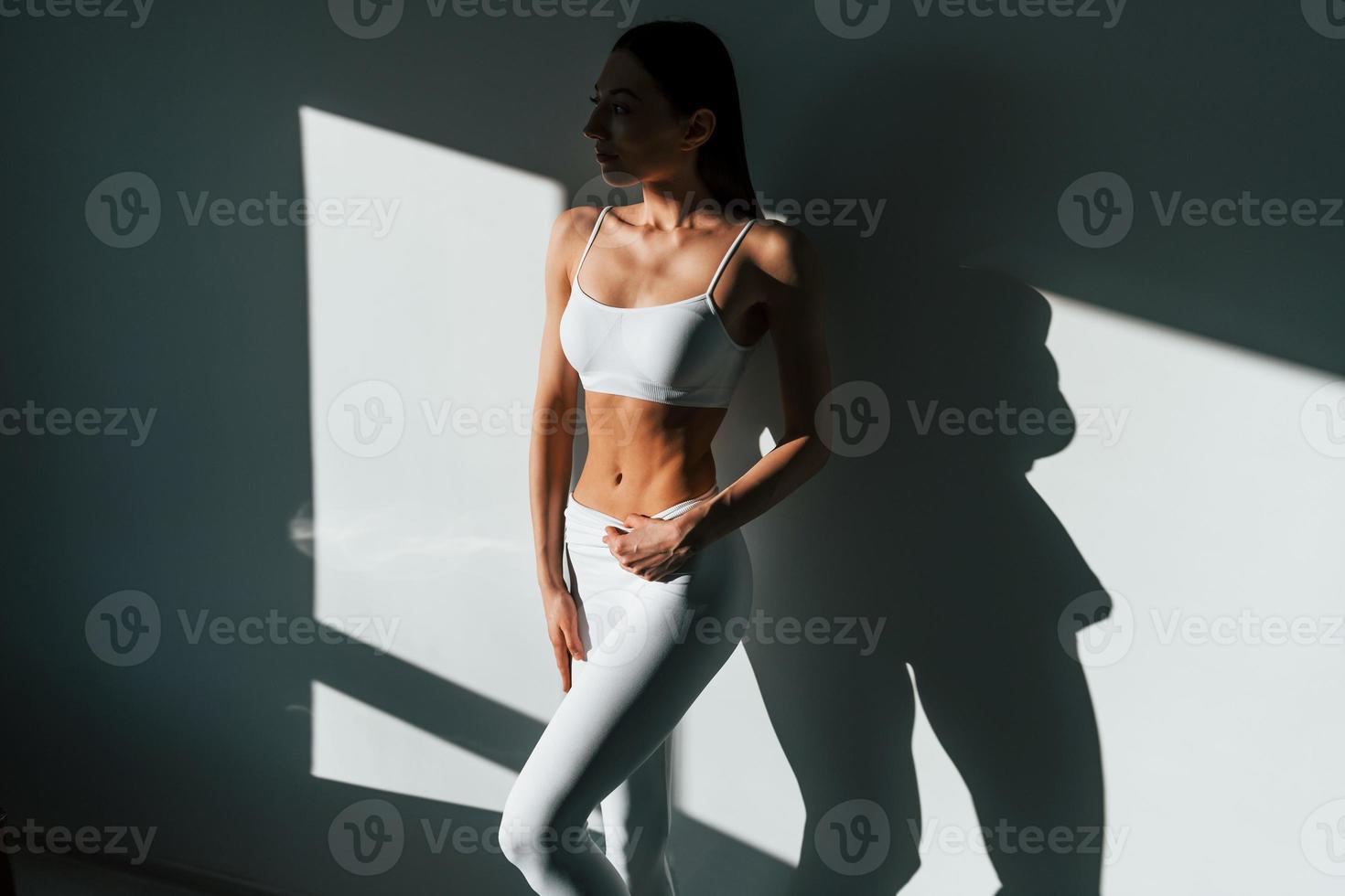 hermosa iluminación. joven mujer caucásica con forma de cuerpo delgado está en el interior durante el día foto