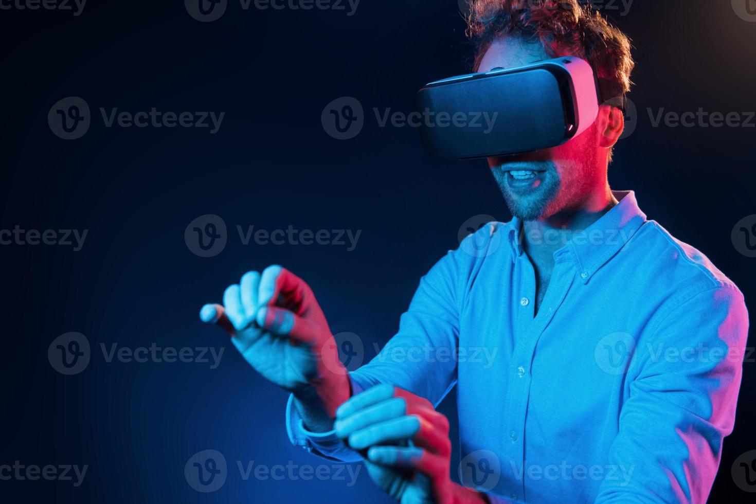 Virtual glasses gaming experience. Neon lighting. Young european man is