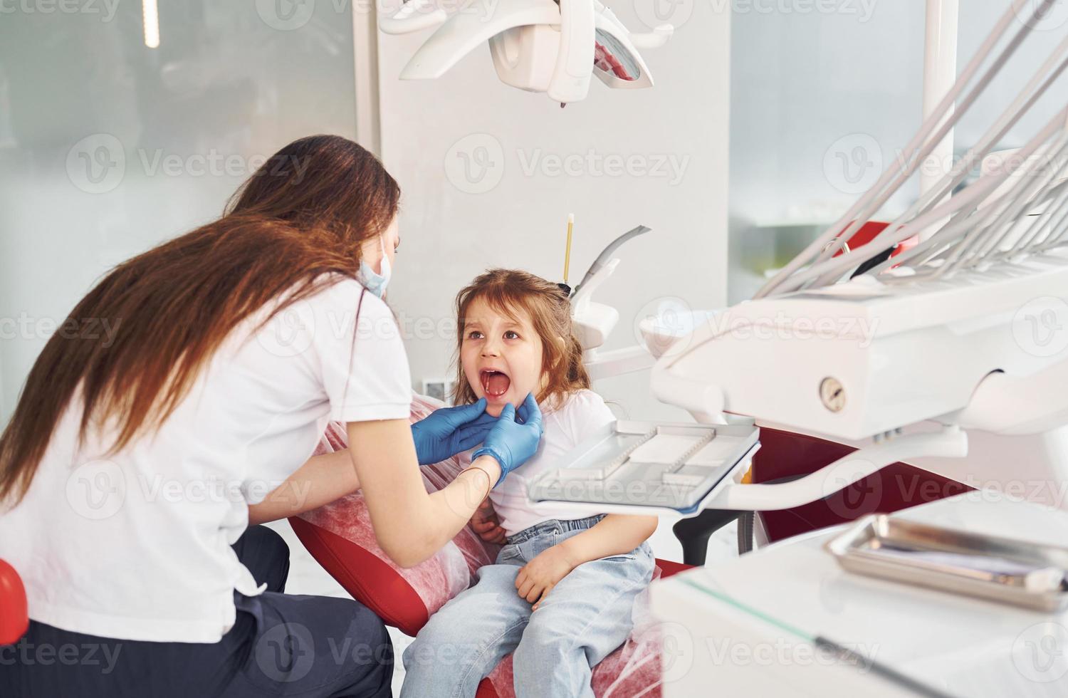 Little girl visiting dentist in clinic. Conception of stomatology photo