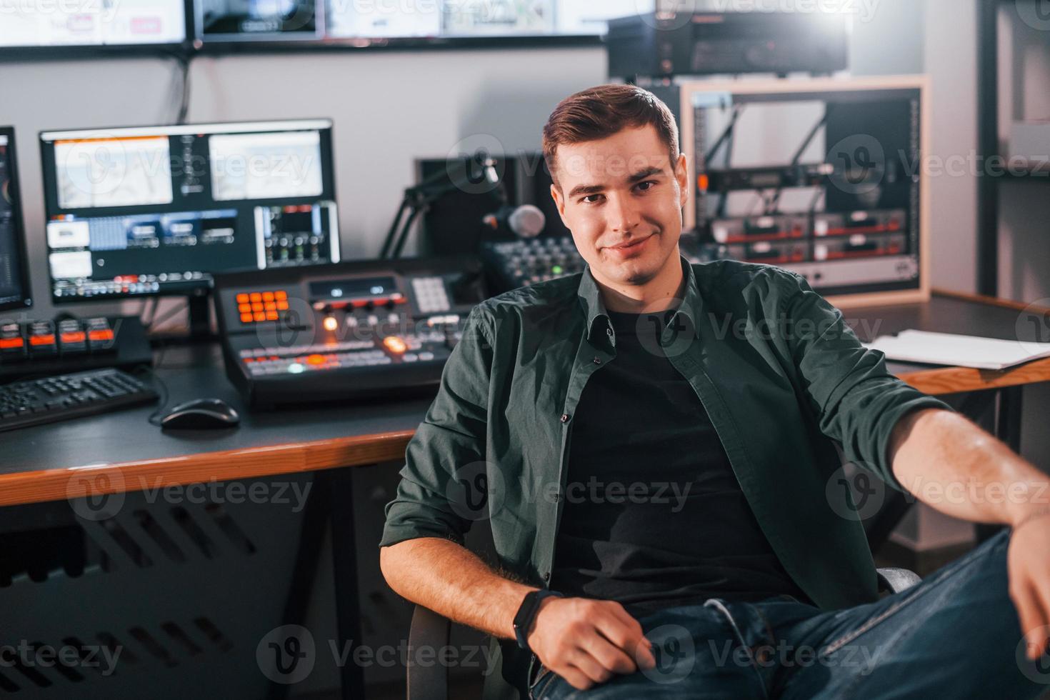 Young man is indoors in the radio studio is busy by broadcast photo
