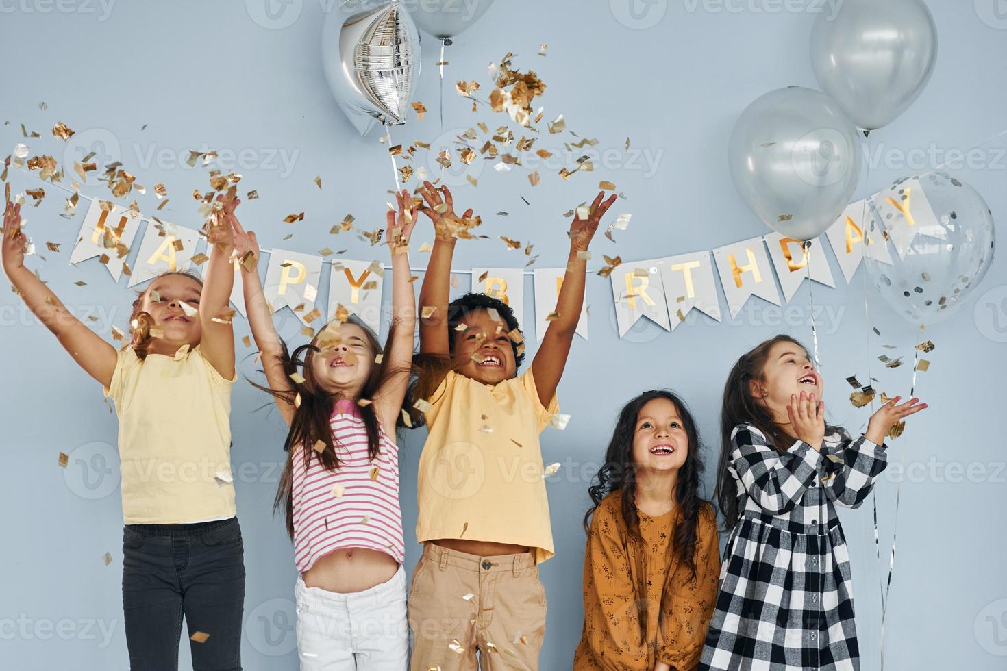 los niños que celebran la fiesta de cumpleaños en el interior se divierten juntos foto