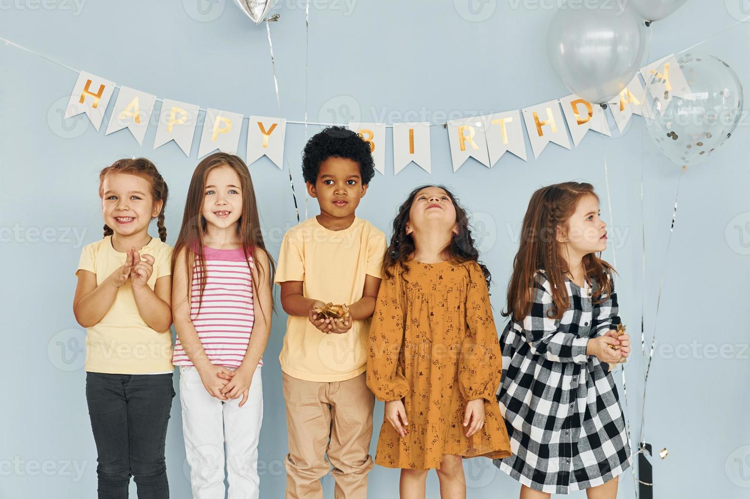 Children on celebrating birthday party indoors have fun together photo