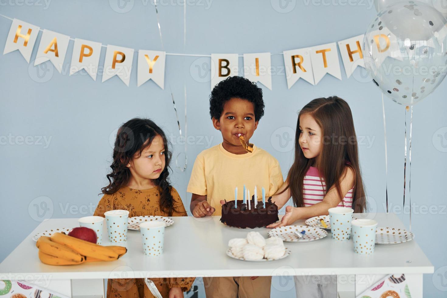 Holiday cake. Children on celebrating birthday party indoors have fun together photo