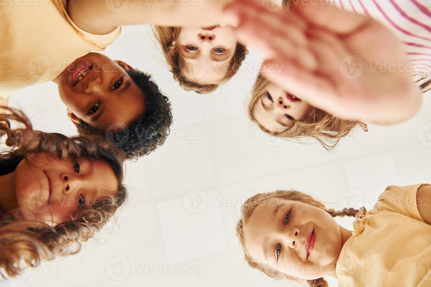 View from below. Children on celebrating birthday party indoors have fun together photo