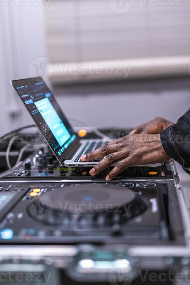 DJ plays live set and mixing music on laptop. Disc Jokey Hands on a