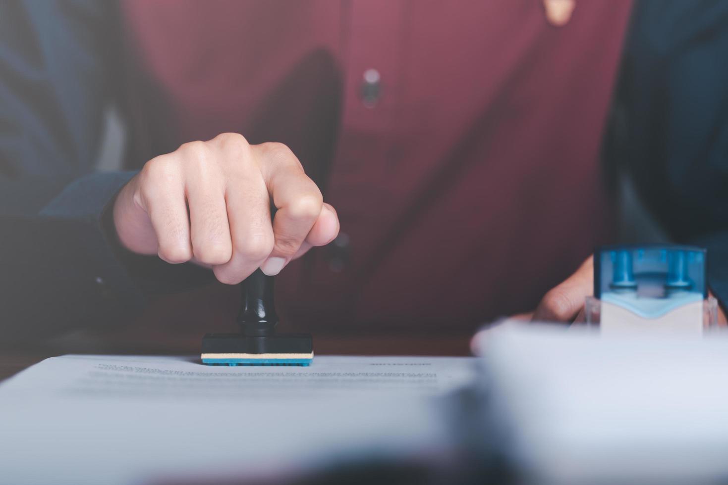 Businessman validates and manages business documents and agreements, signing a business contract approval of contract documents confirmation or warranty certificate,approval stamp photo