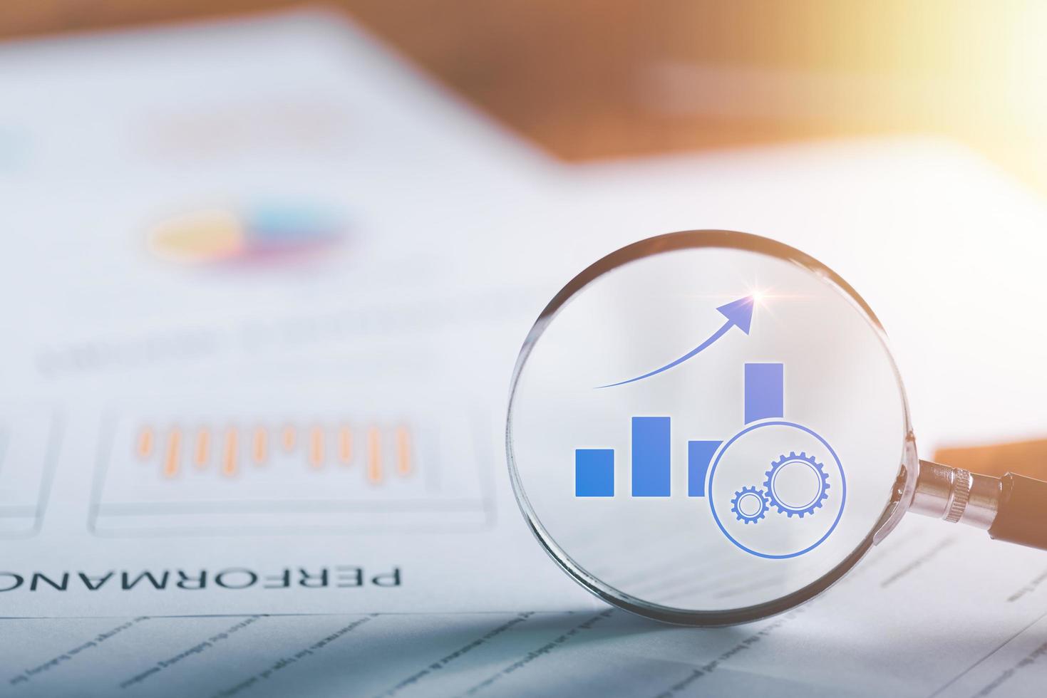 business growth performance monitoring concept,To analyze the achievement of marketing strategy,improvement and development from indicators to develop towards goals,magnifying glass is on the table. photo