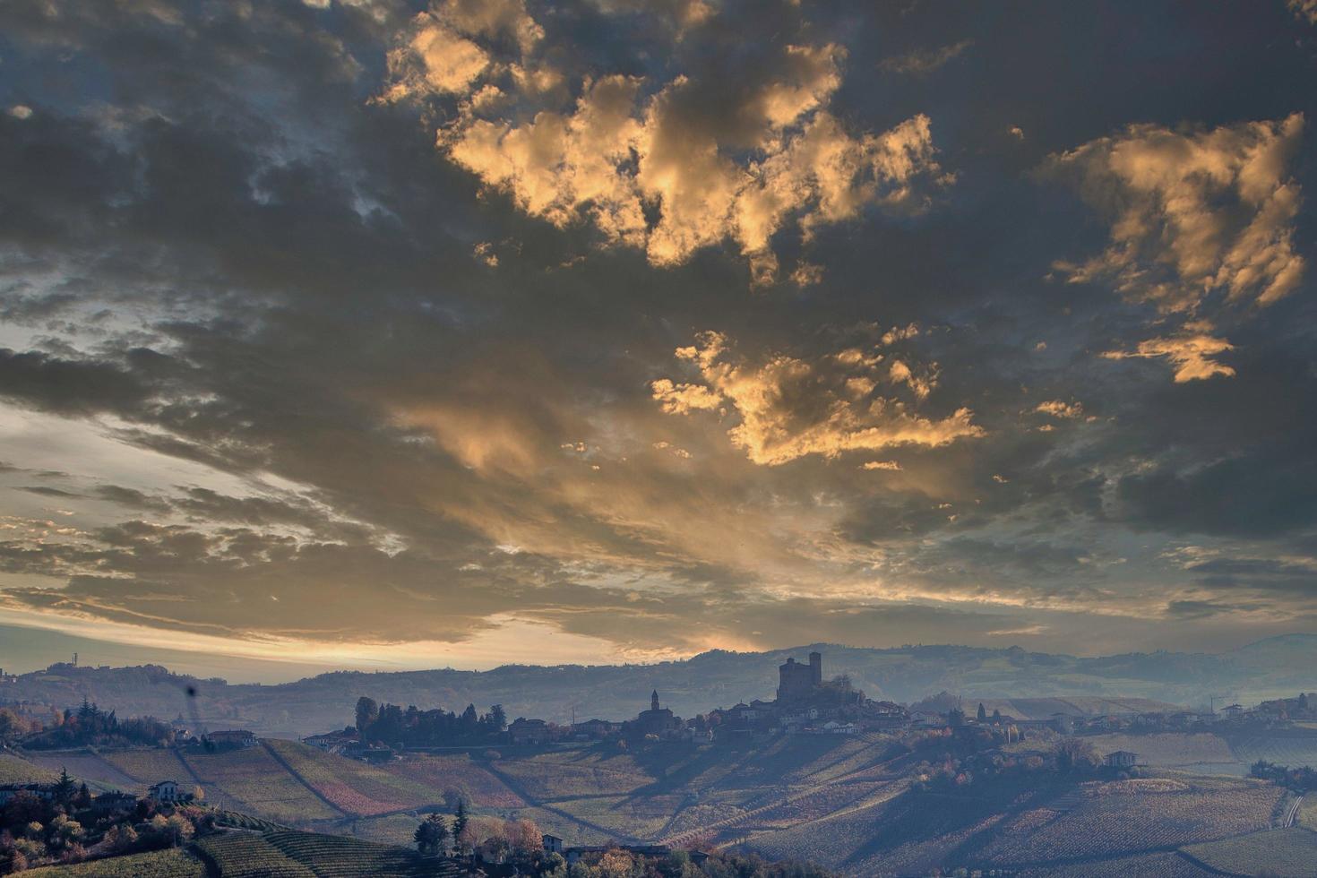 paisajes del langhe piamontés con el famoso castillo medieval de serralunga d'alba, con los colores brillantes de la temporada de otoño foto