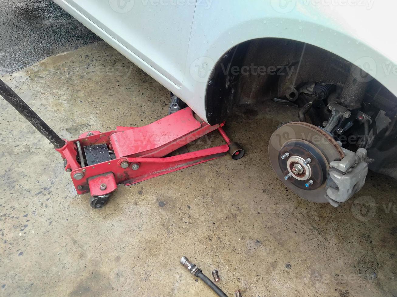 White cars change wheels using a lifting jack. photo