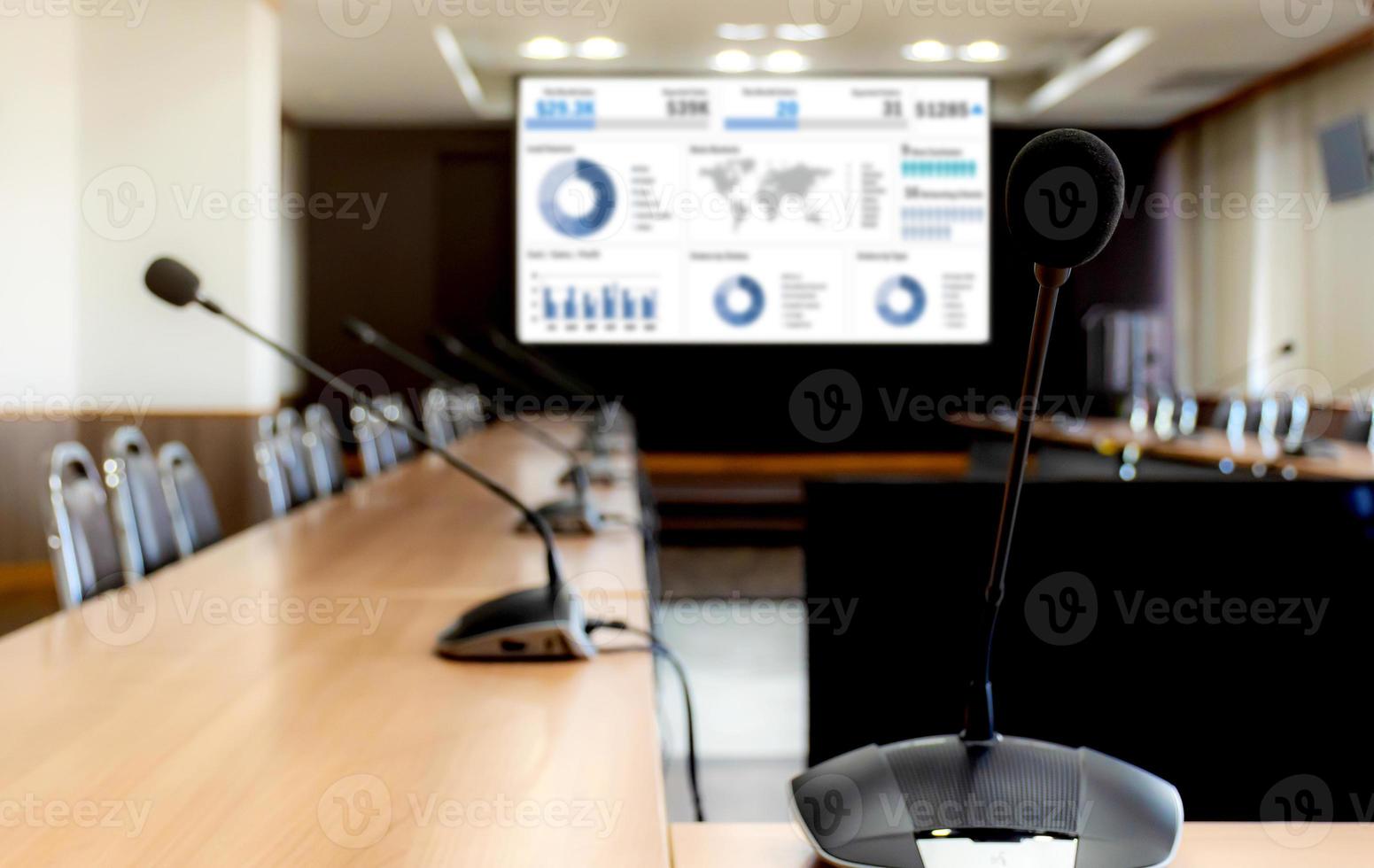 Close up microphone on table with slide presentation on projector screen in meeting room photo