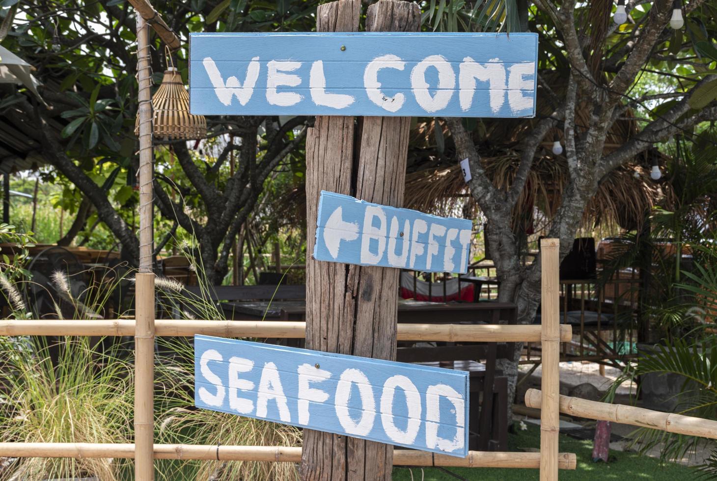 Blue wooden sign with a message Welcome ,Buffet and Seafood photo