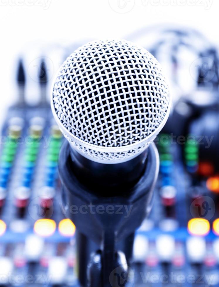 The microphone on tripod in the center of the image with mixer background in sound control room. photo