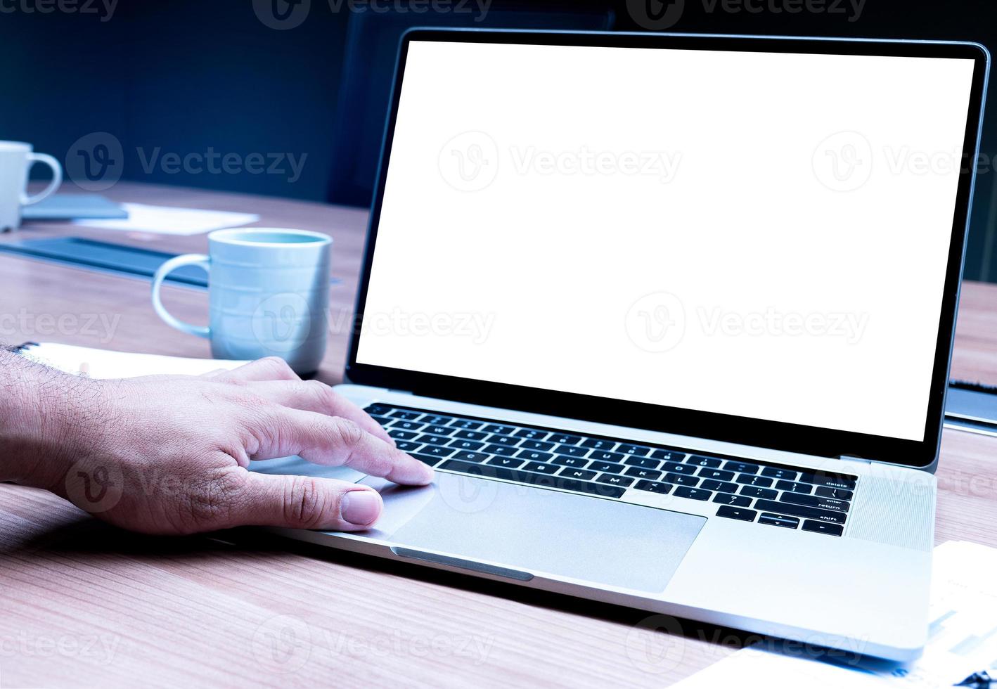 Businessman hand pressing keyboard laptop with mock up sales summary slide show presentation on display laptop and coffee cup on table in meeting room photo
