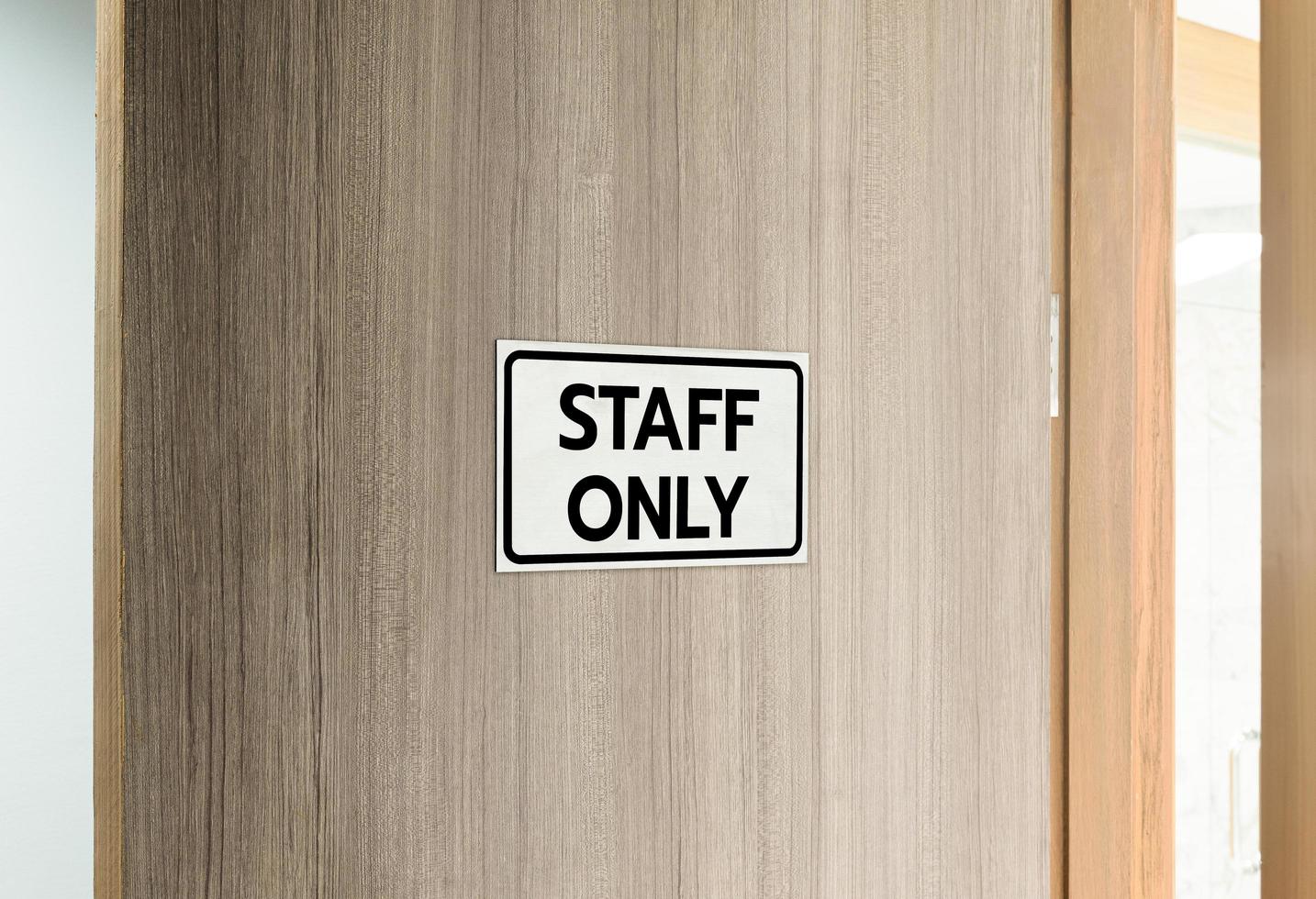 Warning silver stainless steel sign with character black message staff only in front of the wooden door photo