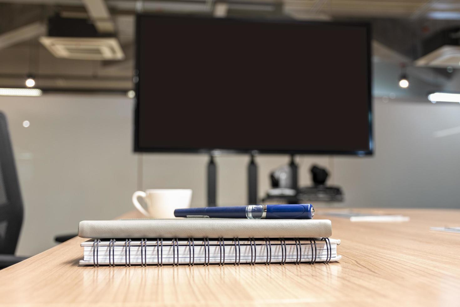 cerrar la pluma y el cuaderno en la mesa en la sala de reuniones foto