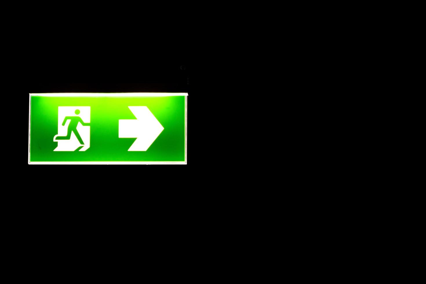 Green emergency exit sing in darkness photo