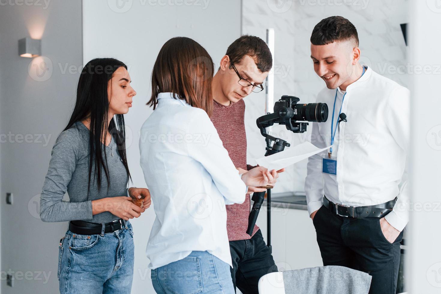Crew of photographers and models is indoors in the modern room photo