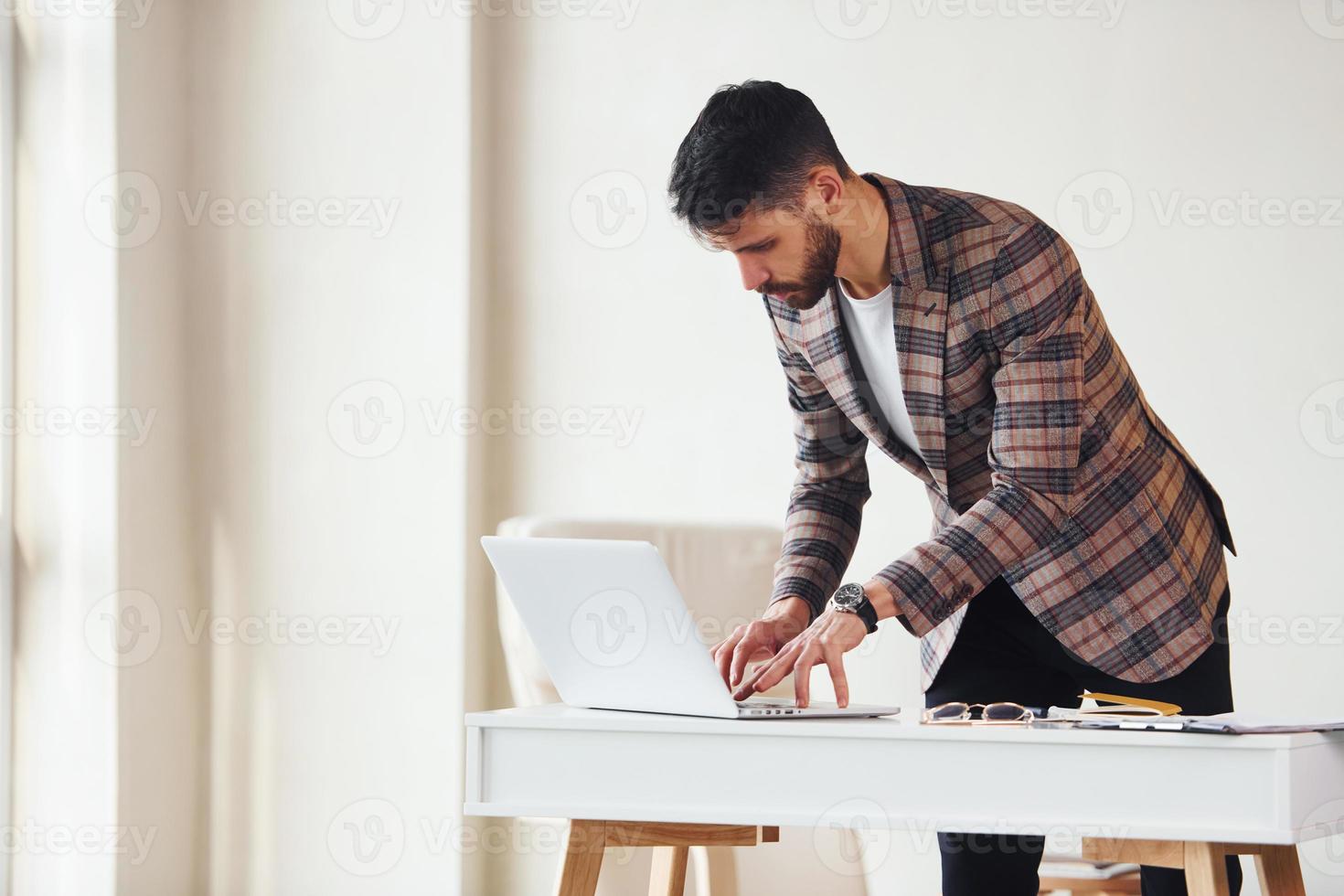 trabaja en la oficina. joven y elegante hombre de negocios con traje en el interior. concepción del éxito foto