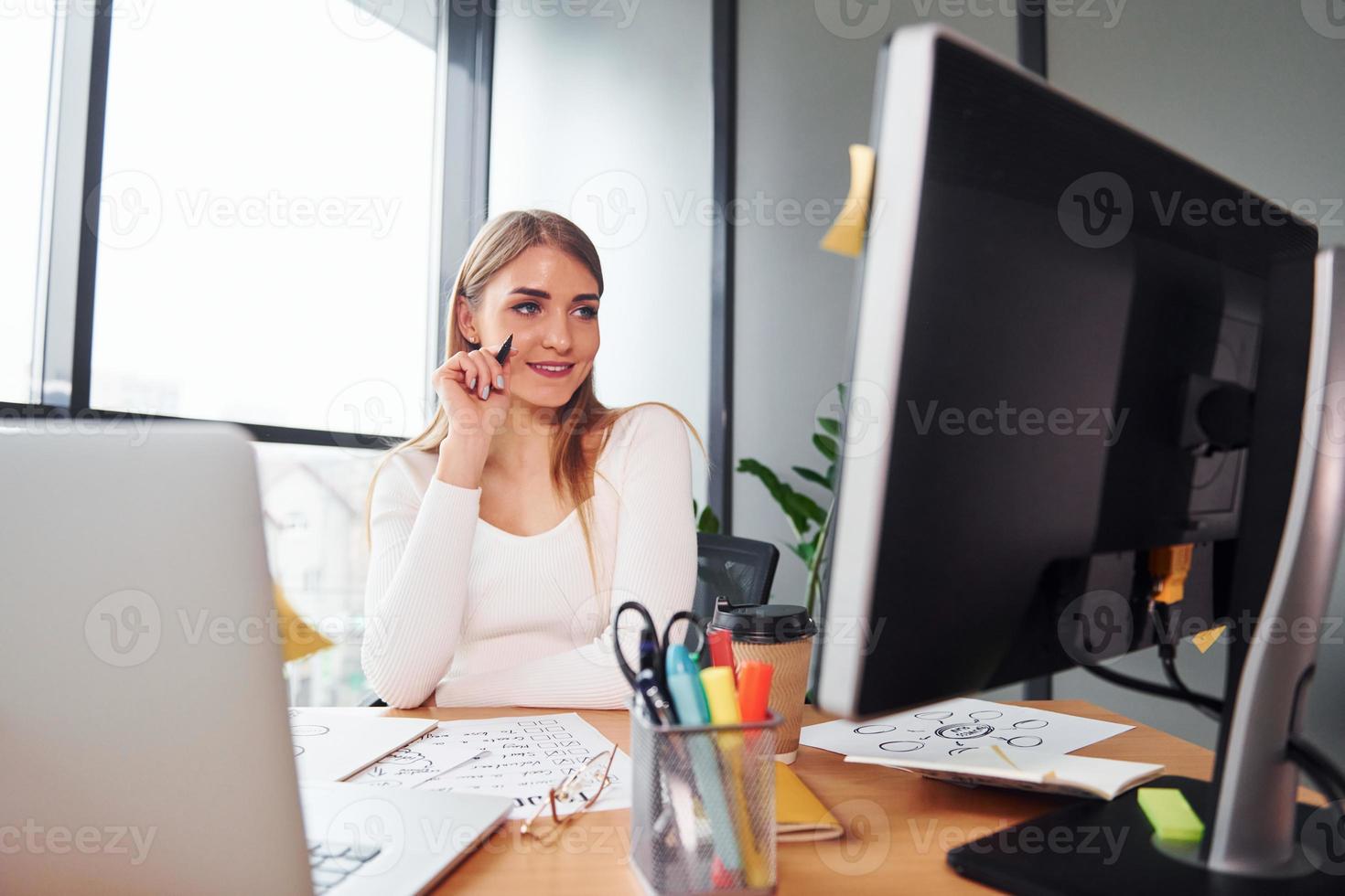 Active working. Young adult woman in formal clothes is indoors in the office photo
