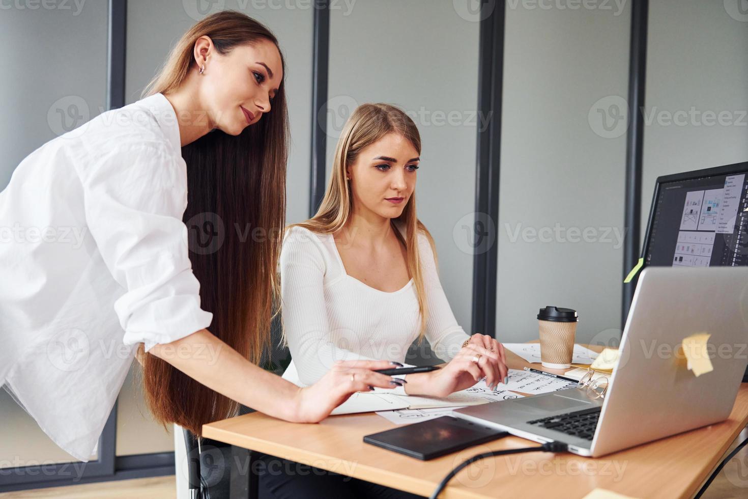 Grupo de mujeres adultas que con ropa formal están juntas en la oficina