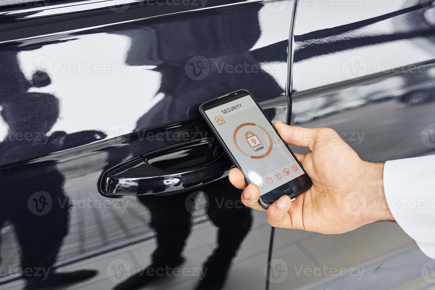 Close up view of man's hand that holds phone with labels and icons. Conception of remote control photo