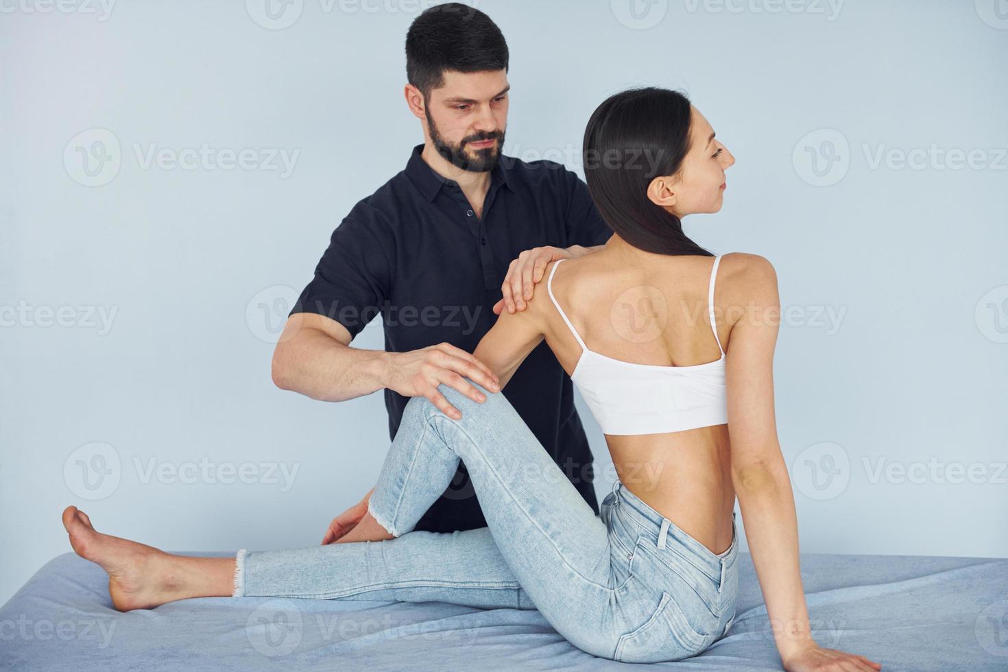 Girl is sitting. Physiotherapist works with young woman indoors in the spa photo