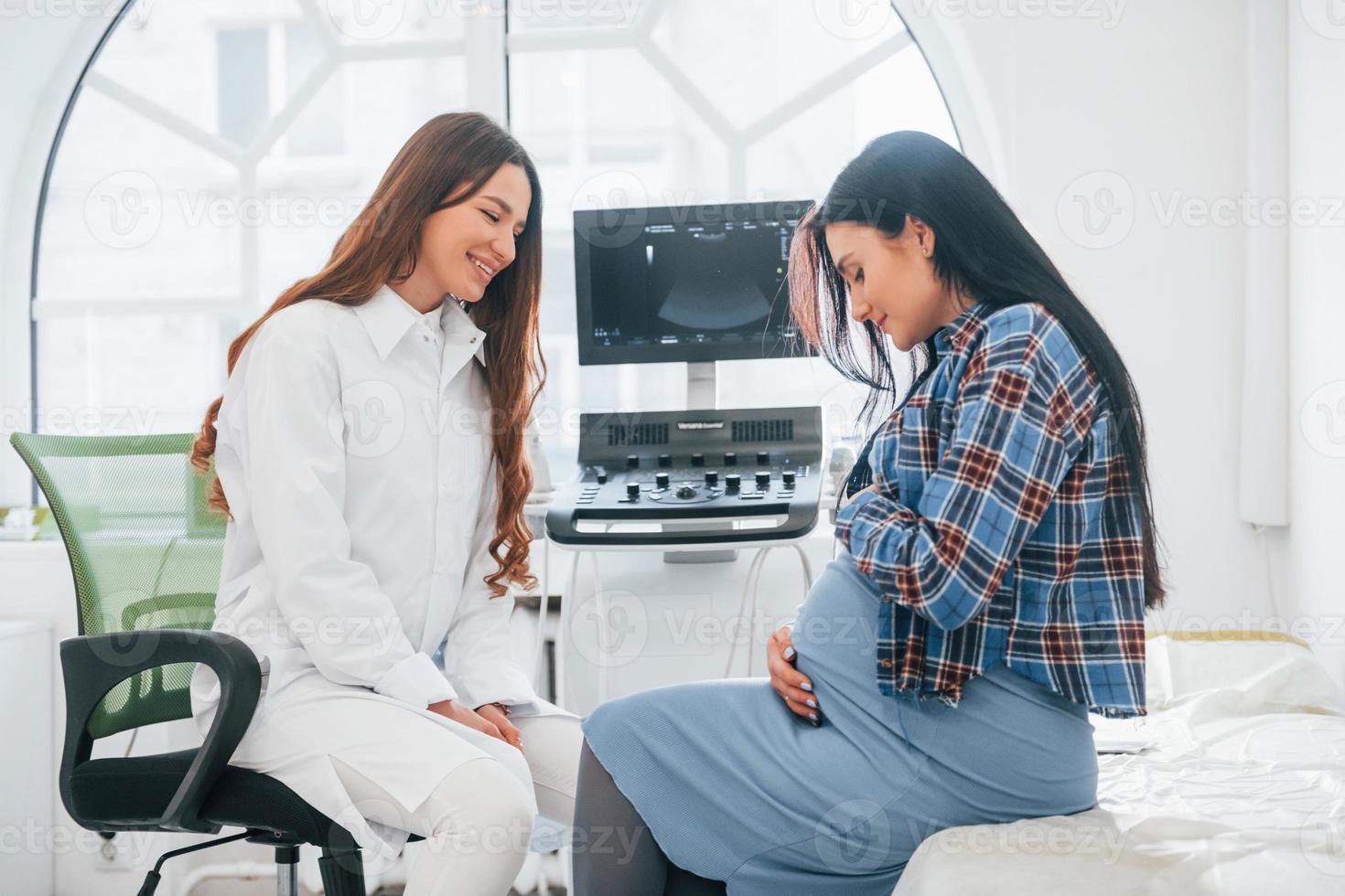 Pregnant woman is in the clinic in cabinet and have health check photo