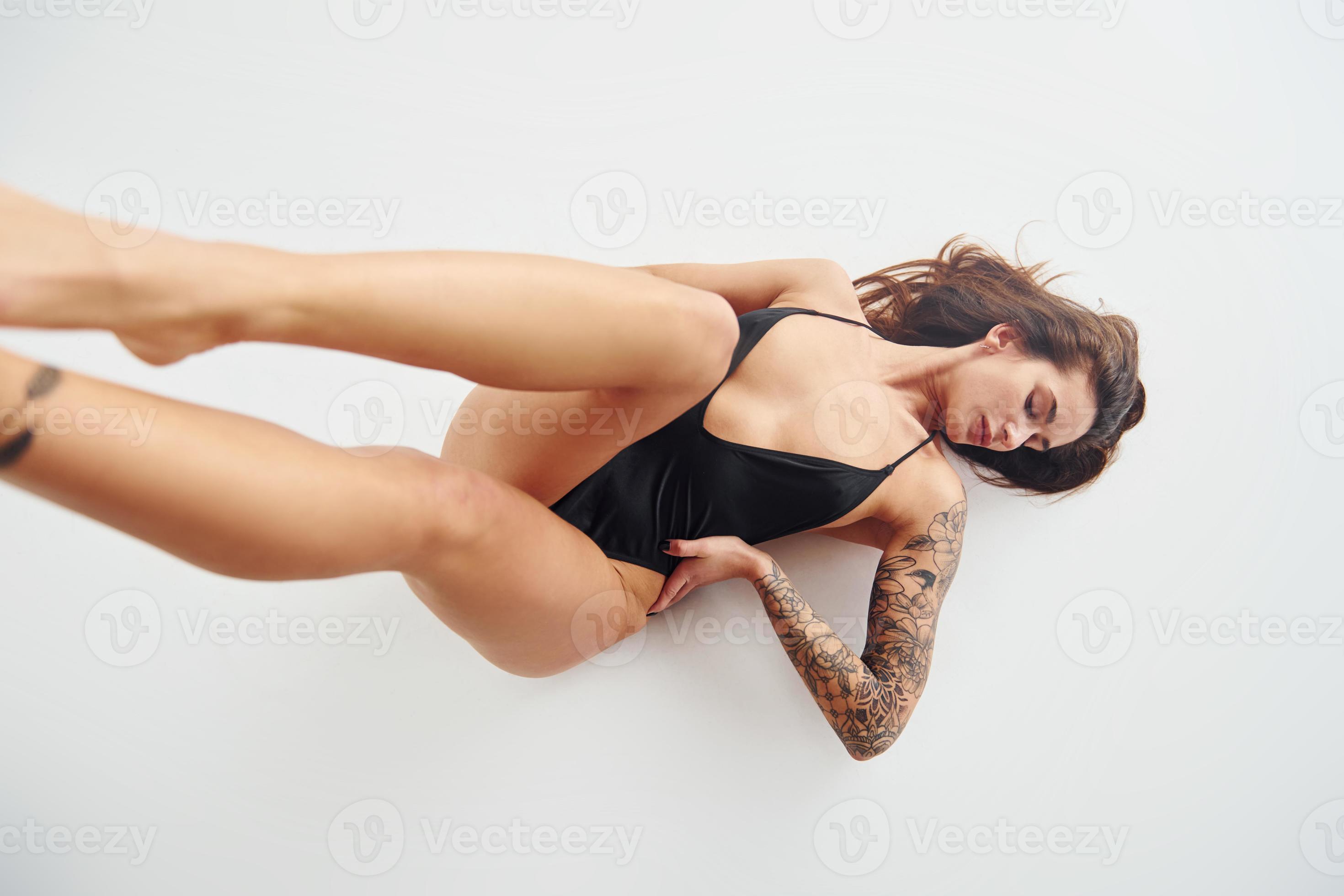 https://static.vecteezy.com/system/resources/previews/015/408/761/large_2x/lying-down-on-the-ground-beautiful-seductive-sporty-woman-with-sexy-body-is-posing-in-the-studio-photo.jpg