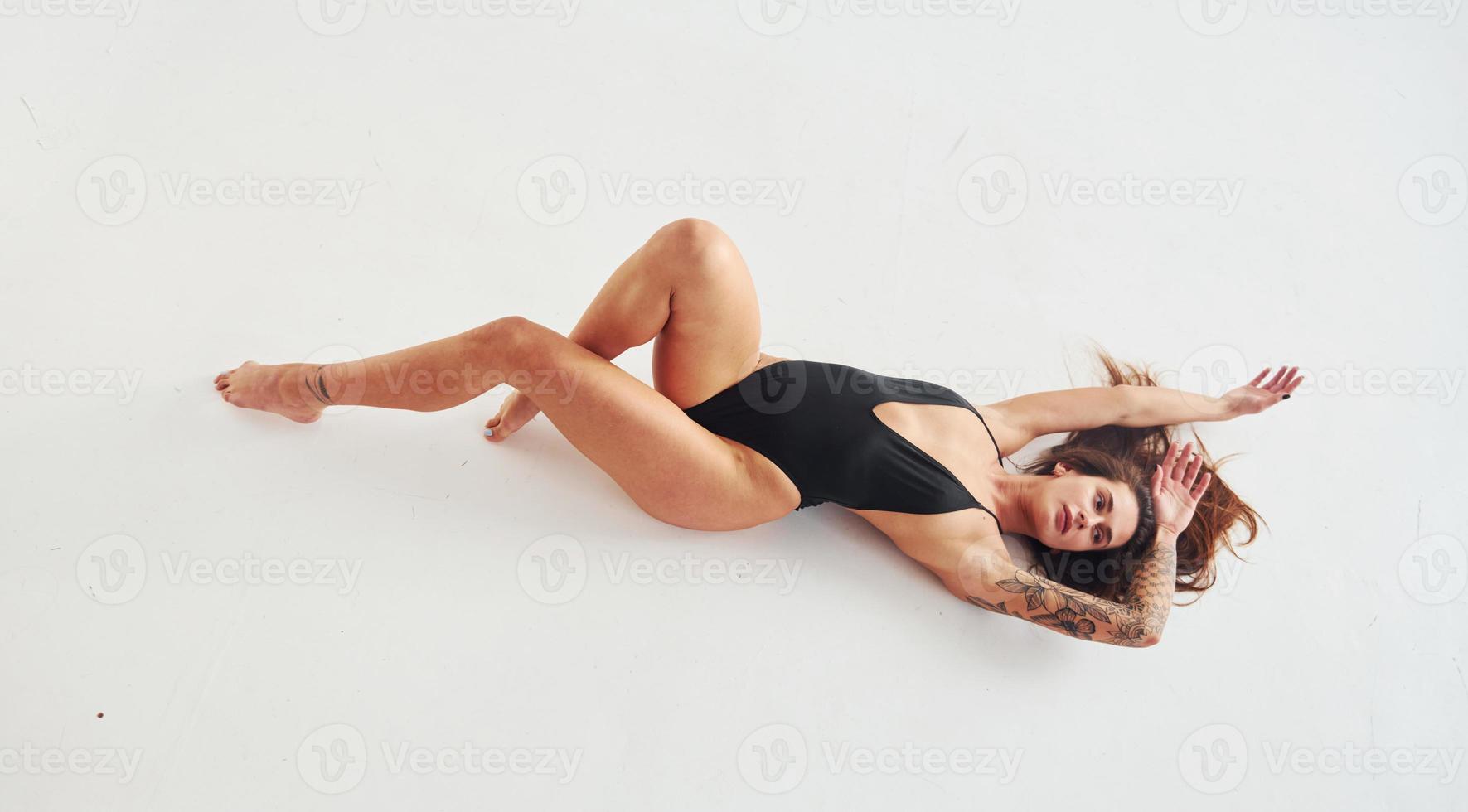 Beautiful seductive sporty woman with sexy body is posing in the studio photo