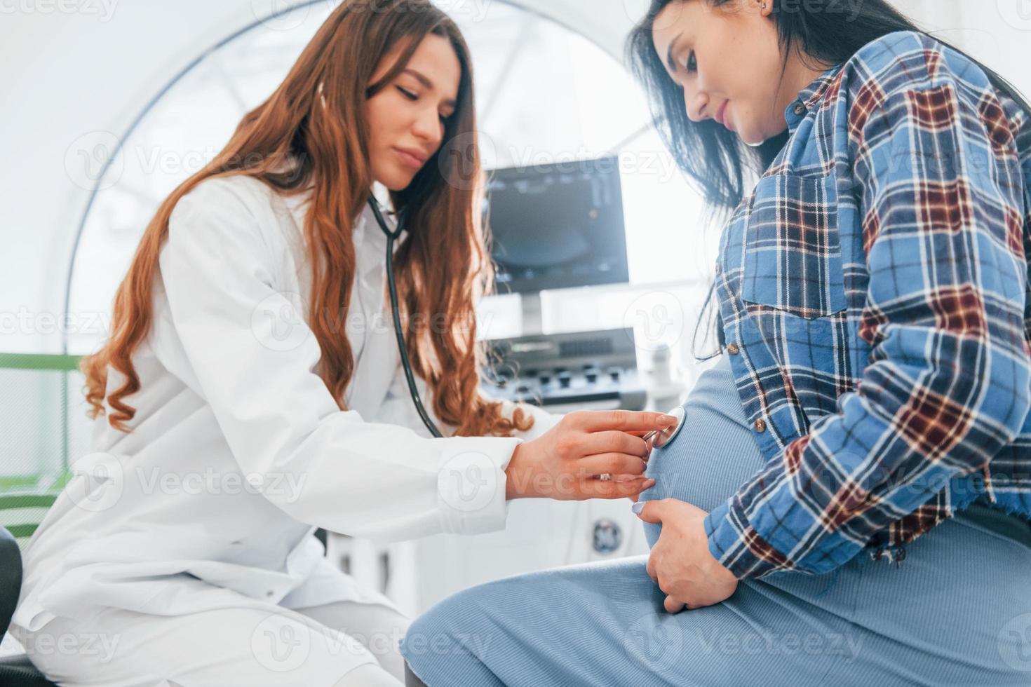 Pregnant woman is in the clinic in cabinet and have health check photo