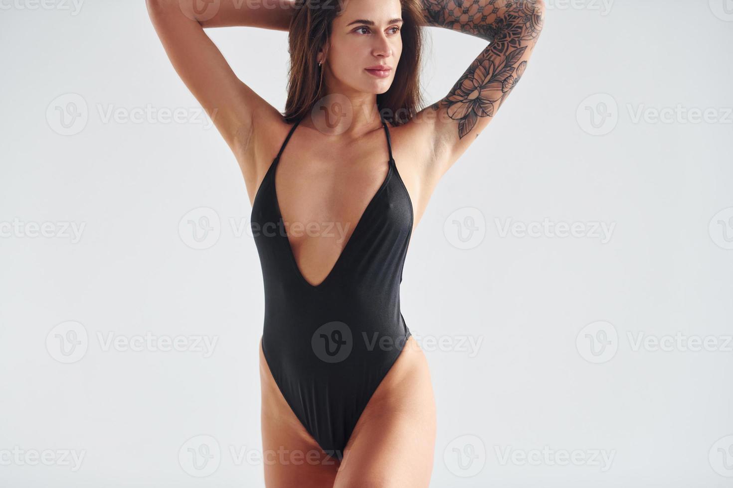 Standing and posing. Beautiful seductive sporty woman with sexy body is in the studio photo