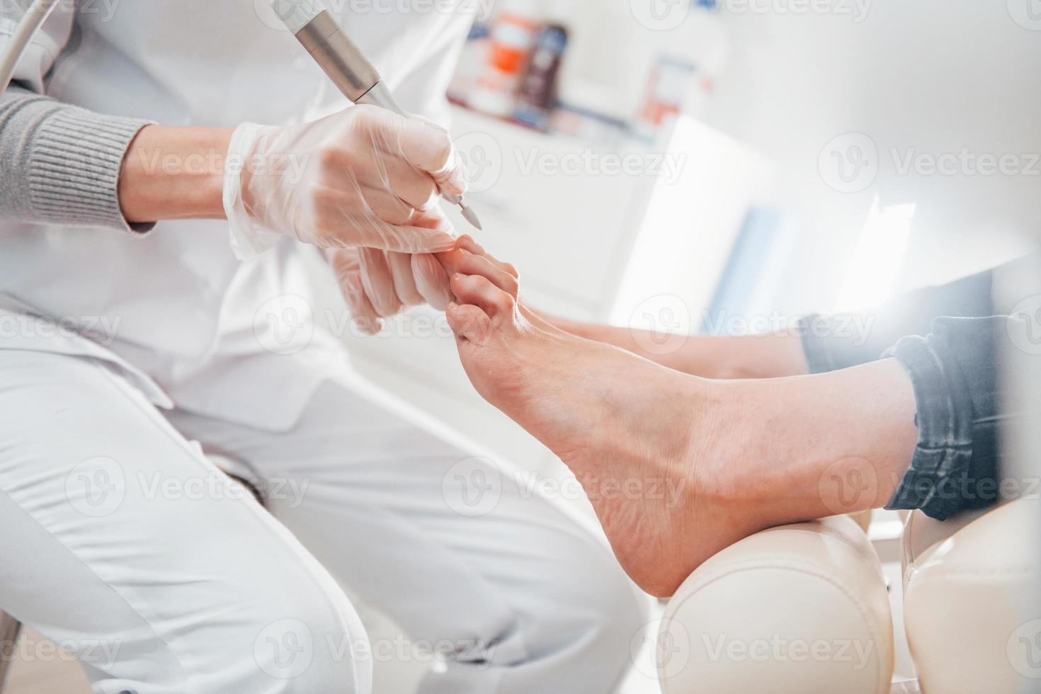 Woman lying down and have operation on her feet by professional clinic worker photo