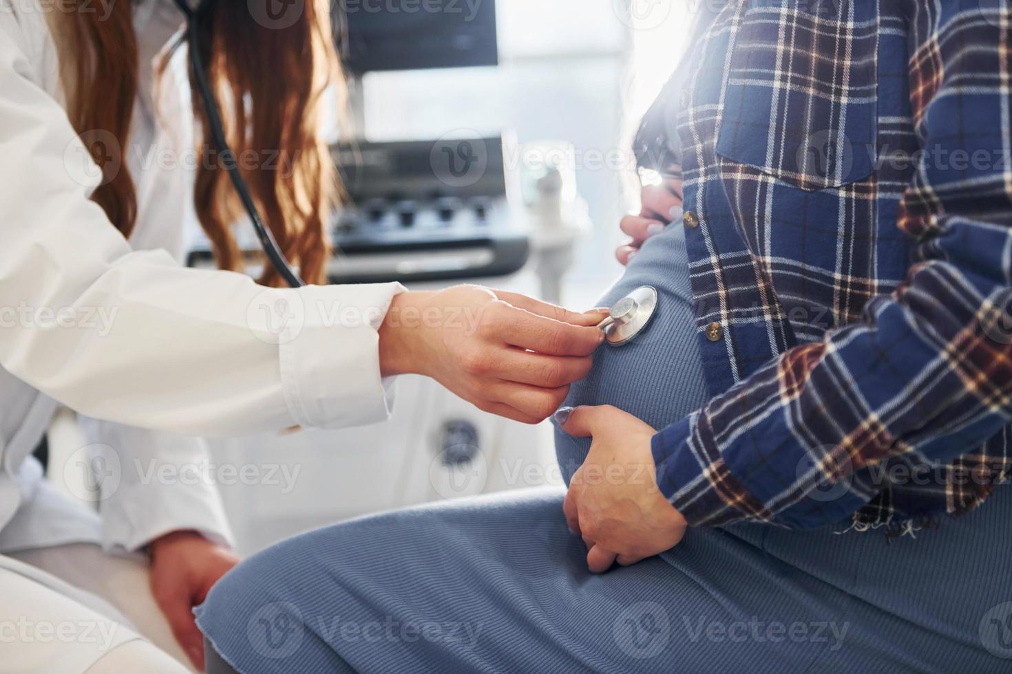 Pregnant woman is in the clinic in cabinet and have health check photo