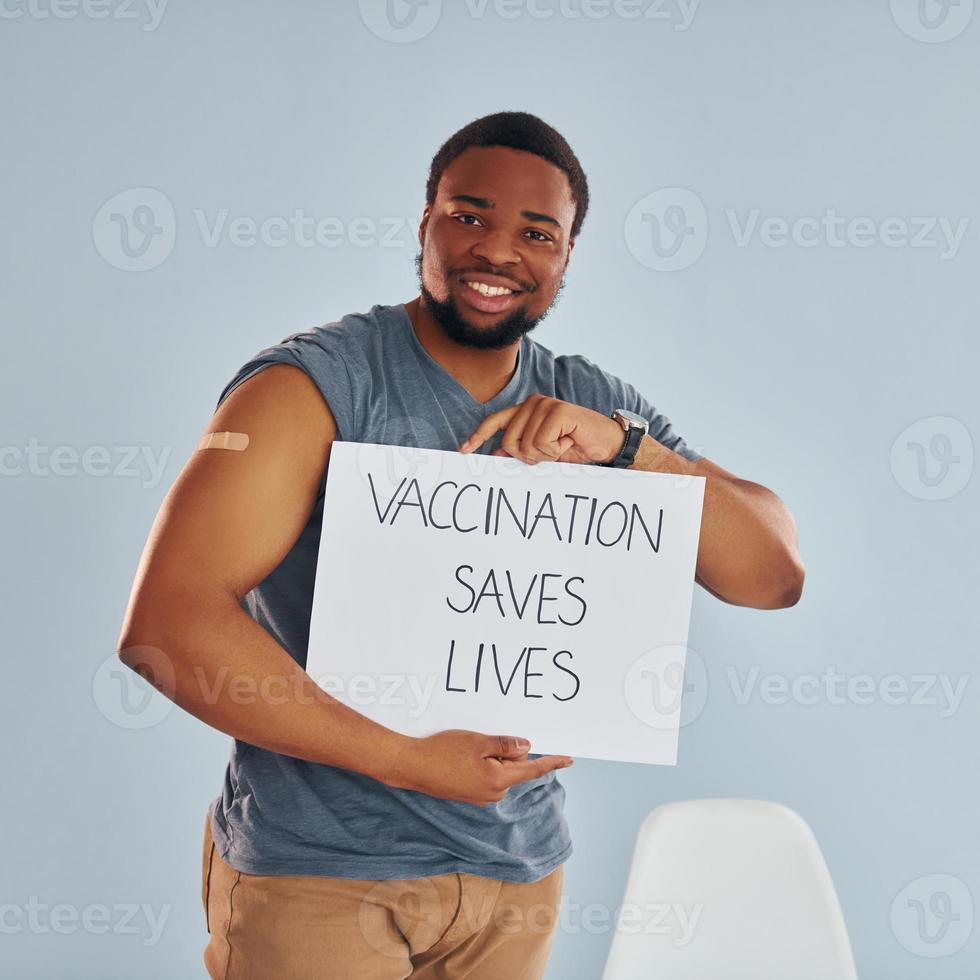 Vaccination saves lives banner. Young african american man after vaccine injection photo