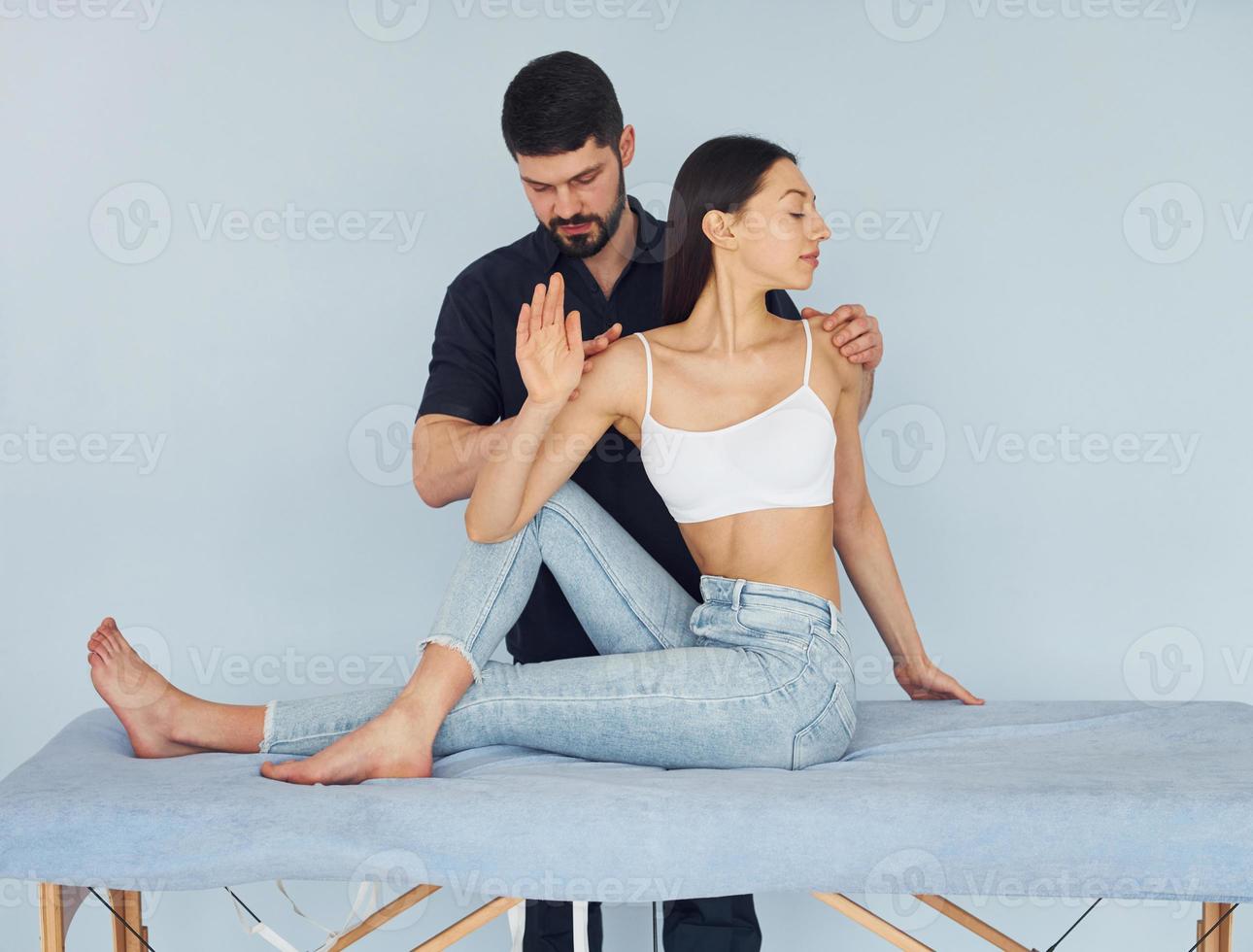 Girl is sitting. Physiotherapist works with young woman indoors in the spa photo