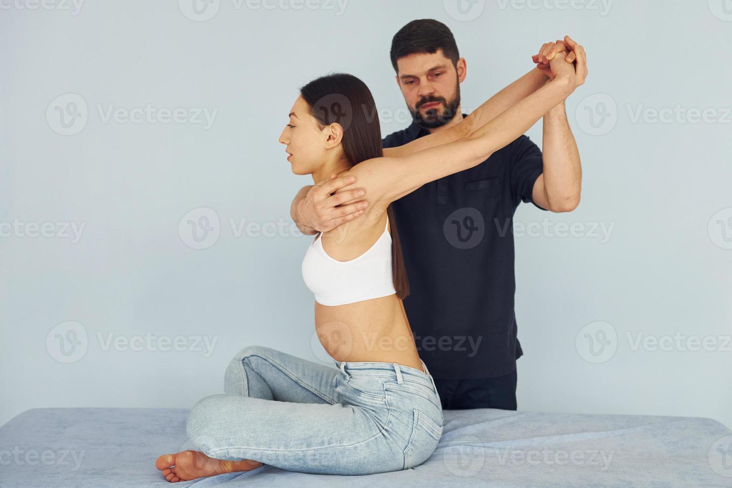 Girl is sitting. Physiotherapist works with young woman indoors in the spa photo