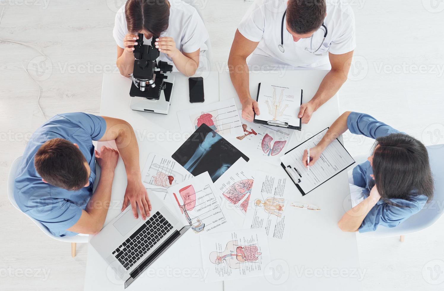 vista superior. grupo de médicos jóvenes está trabajando juntos en la oficina moderna foto