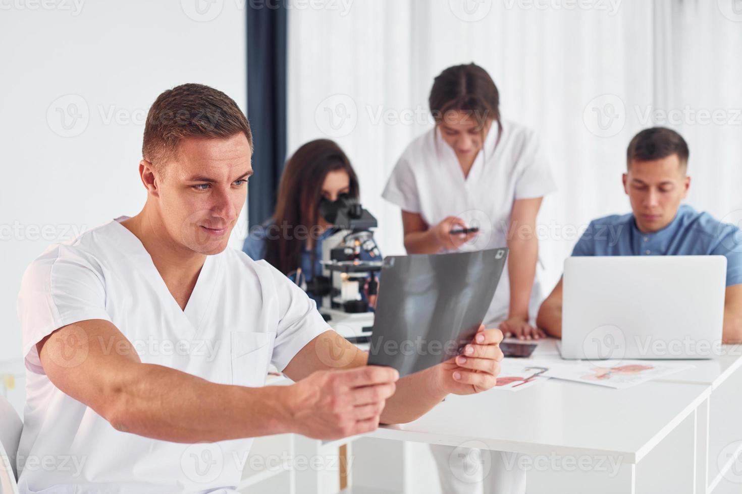 radiografía de piernas. grupo de médicos jóvenes está trabajando juntos en la oficina moderna foto