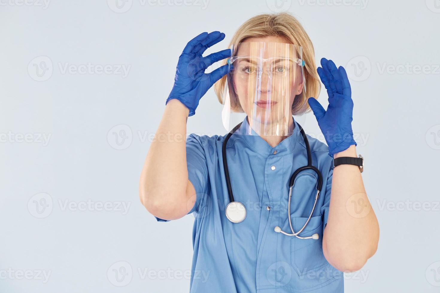 Middle-aged professional female doctor in uniform and with stethoscope photo