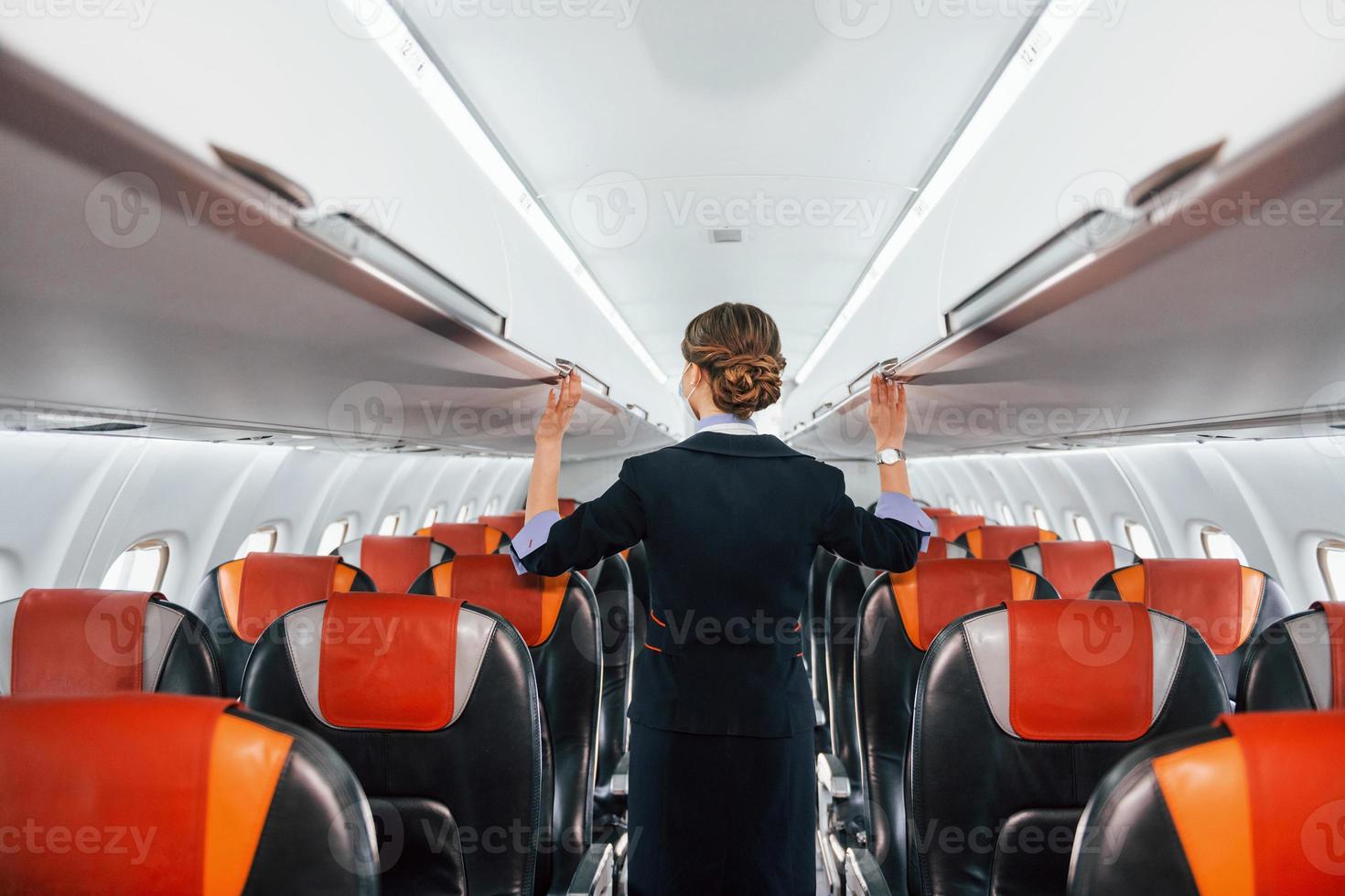 Empty seats. Young stewardess on the work in the passanger airplane photo