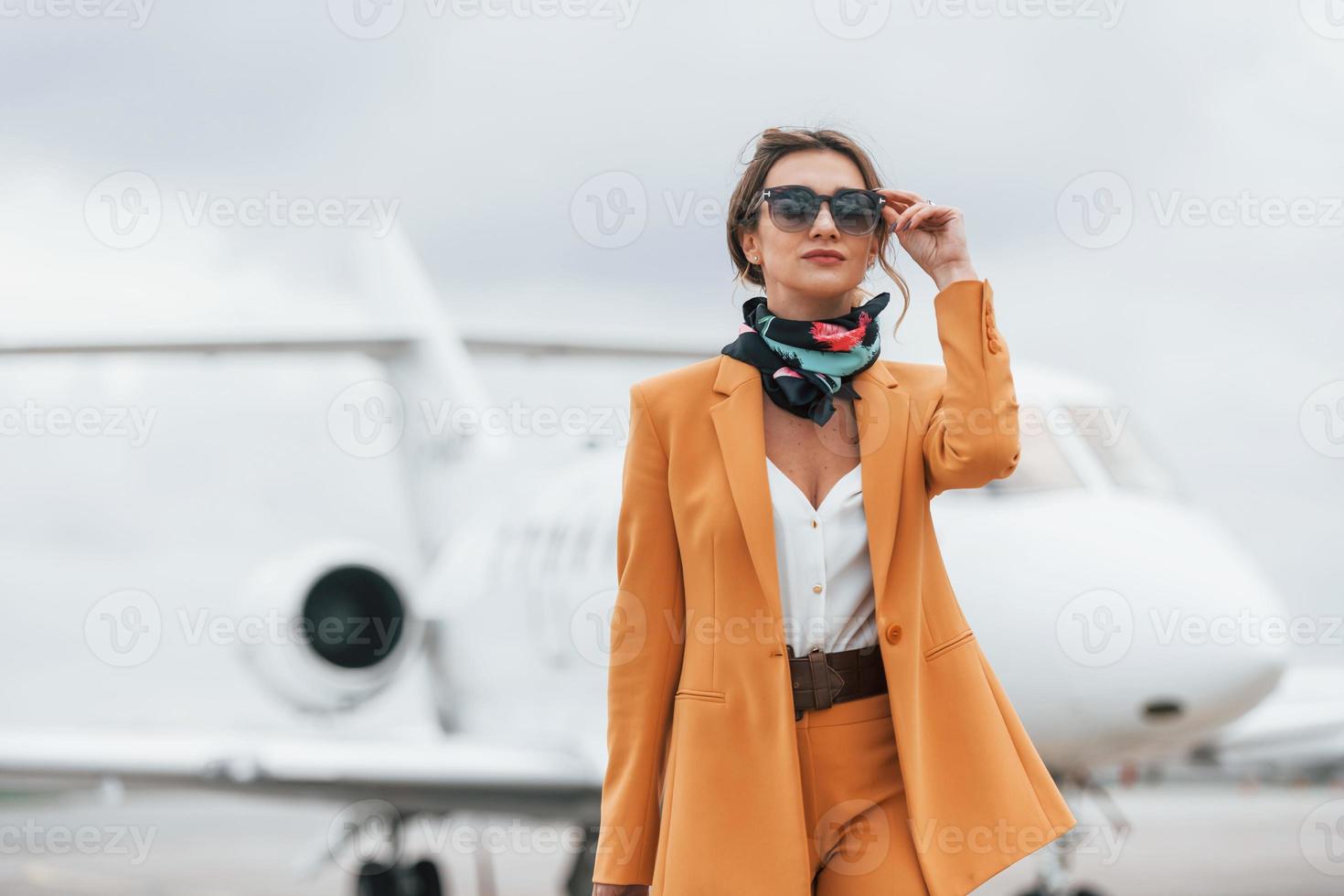 Conception of tourism. Passenger woman that is in yellow clothes and sunglasses photo