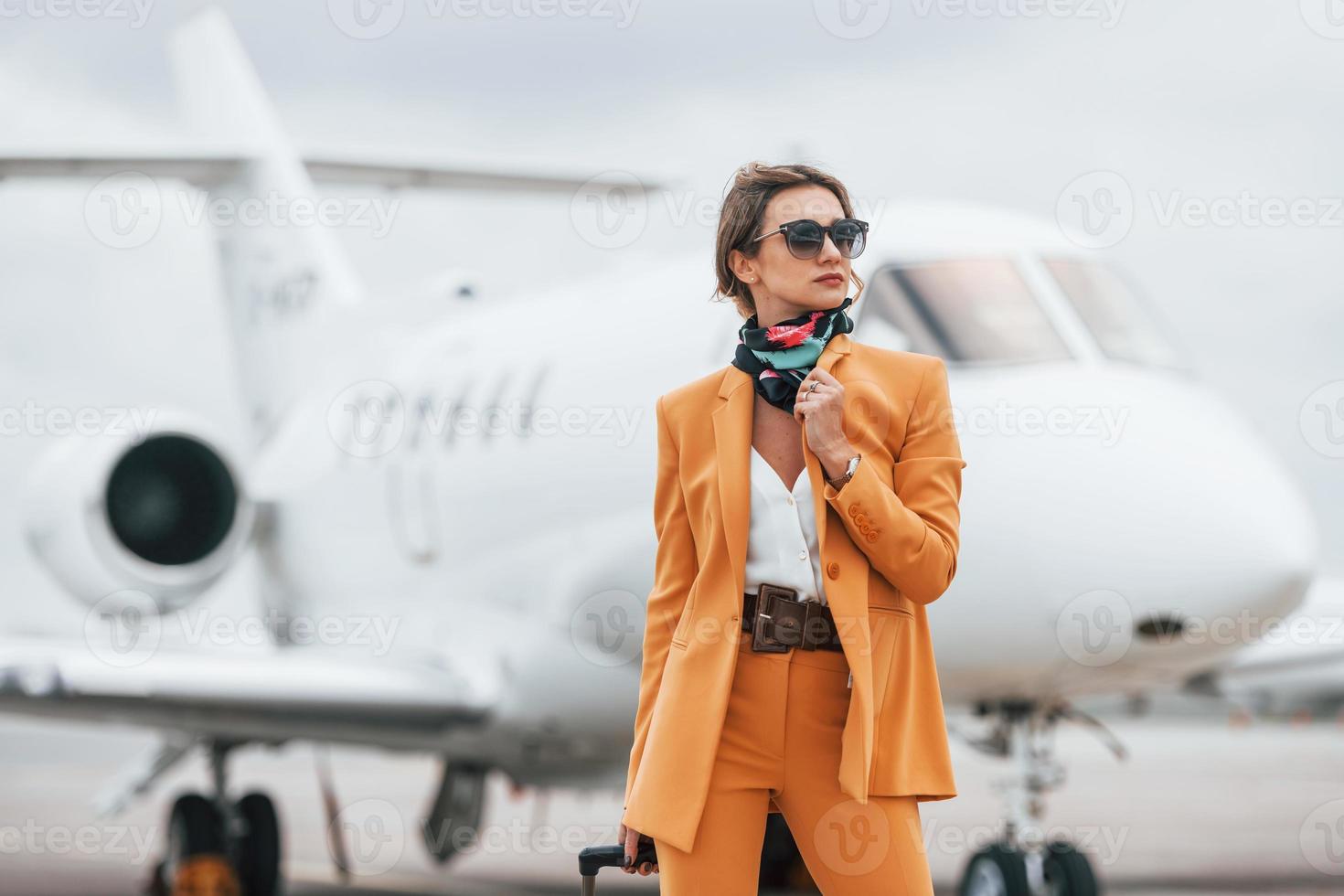 Conception of tourism. Passenger woman that is in yellow clothes and sunglasses photo