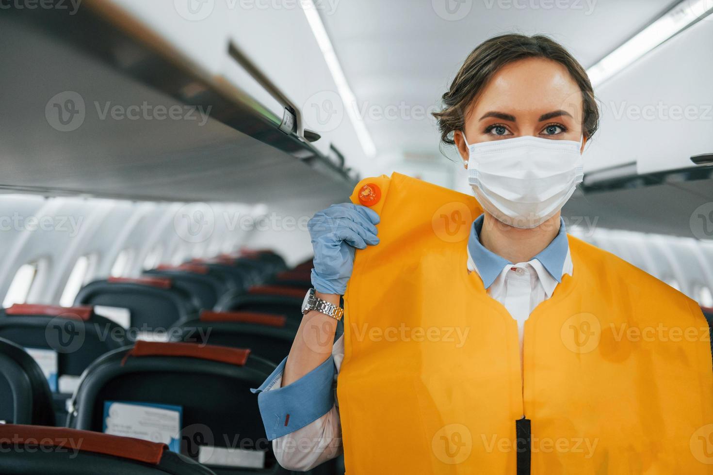 Safety instructions. Young stewardess on the work in the passanger airplane photo
