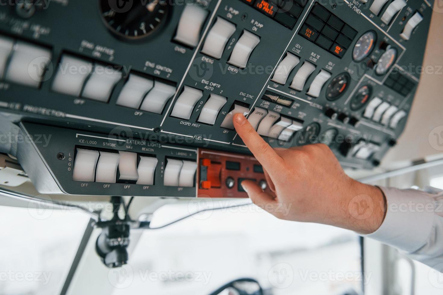 Close up view. Pilot on the work in the passenger airplane. Preparing for takeoff photo