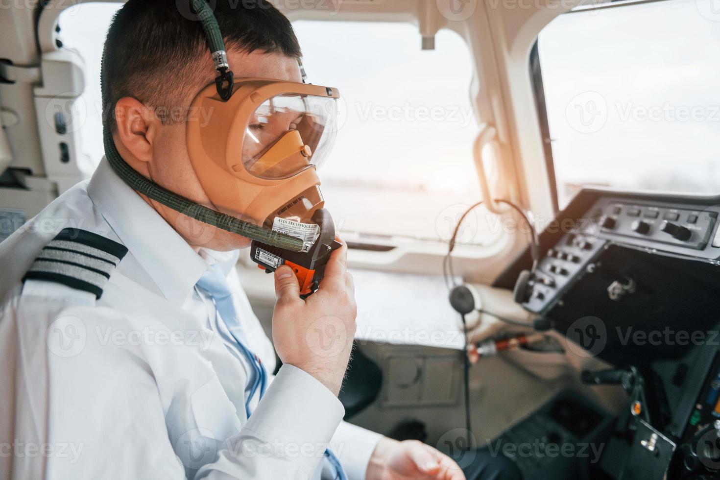 In oxygen mask. Pilot on the work in the passenger airplane. Preparing for takeoff photo