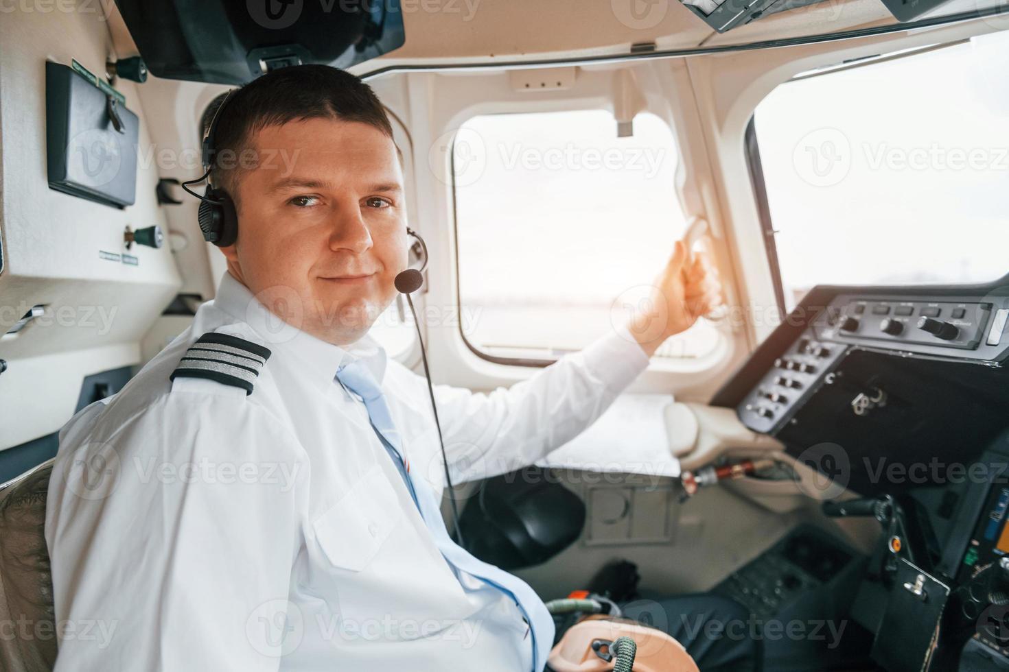 Pilot on the work in the passenger airplane. Preparing for takeoff photo