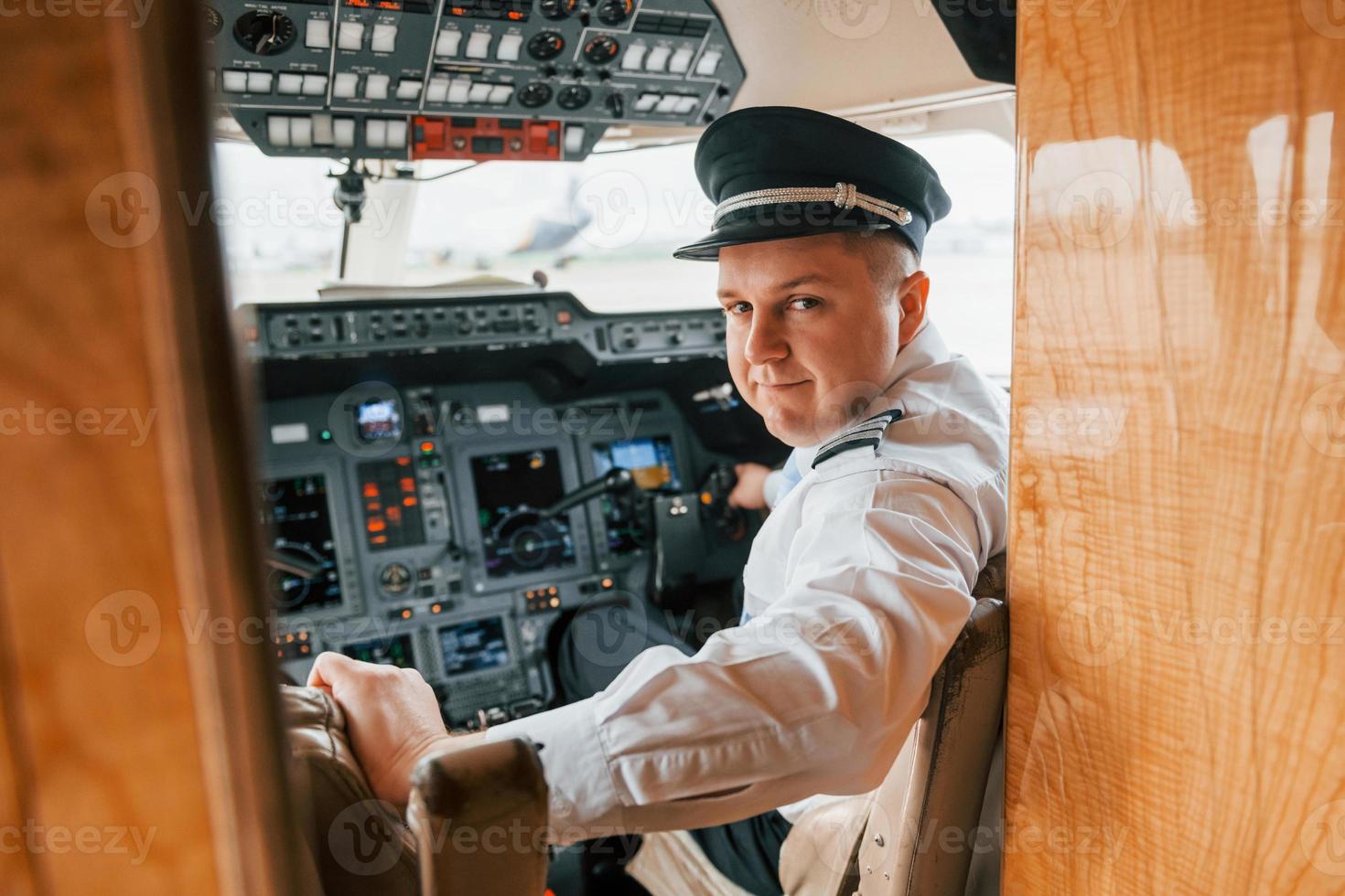 Looks behind. Pilot on the work in the passenger airplane. Preparing for takeoff photo