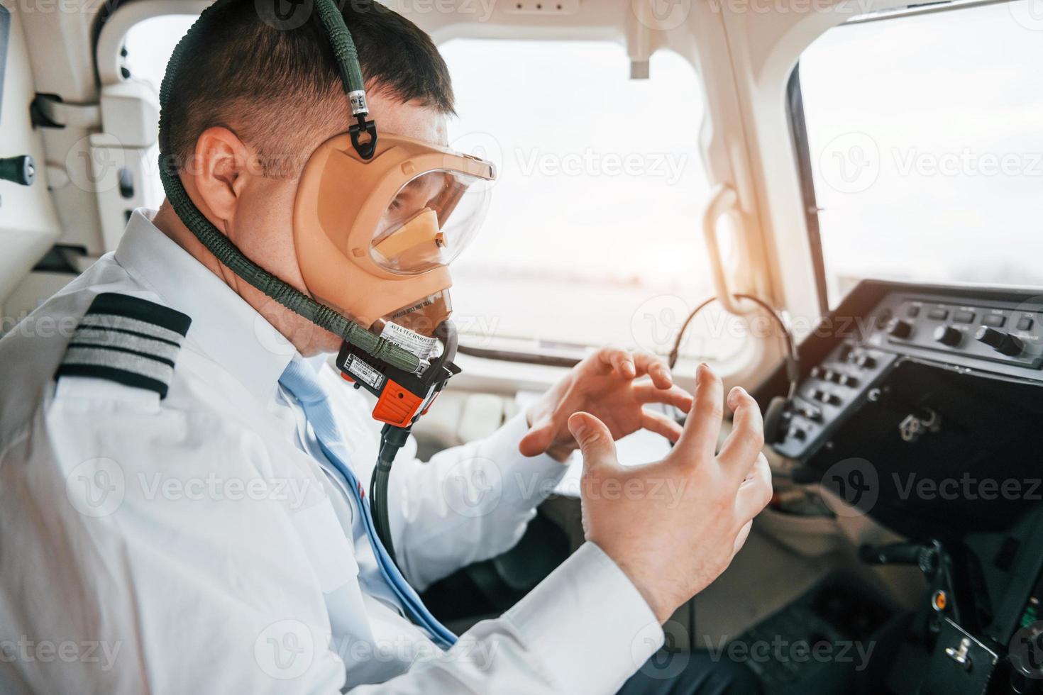 In oxygen mask. Pilot on the work in the passenger airplane. Preparing for takeoff photo