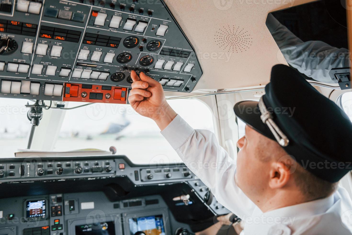 Close up view. Pilot on the work in the passenger airplane. Preparing for takeoff photo