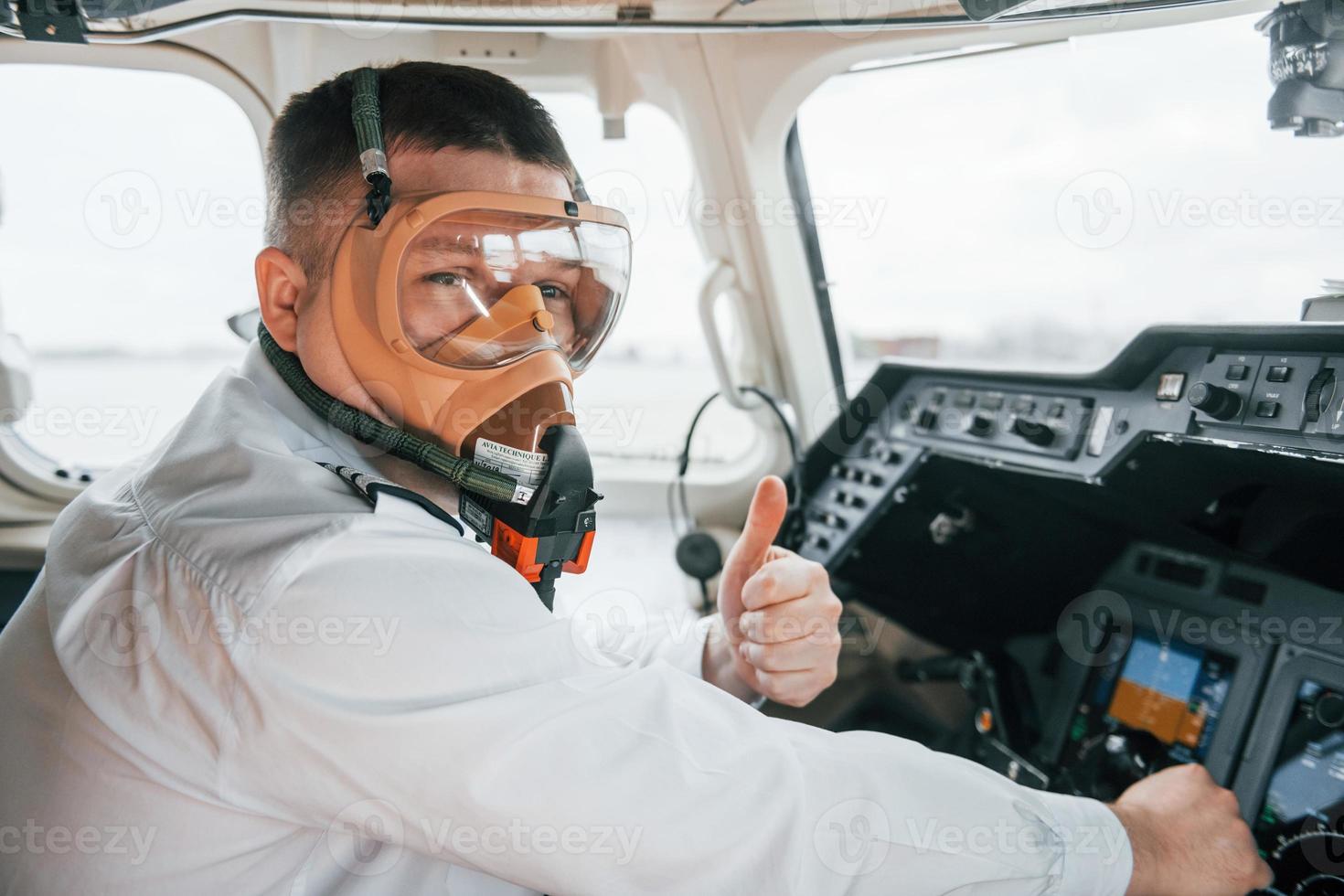 In oxygen mask. Pilot on the work in the passenger airplane. Preparing for takeoff photo